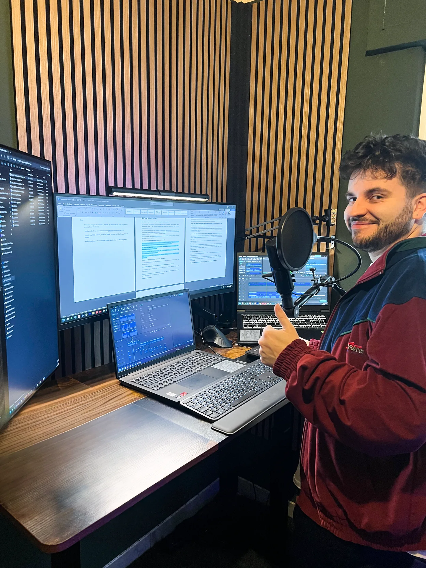 Valentin Witt am Aufnahmeplatz mit Mikrofon, mehreren Monitoren und Audioprojekten